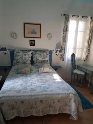a bedroom with a bed and a table and a window at Hôtel Restaurant L'Aiglon in Zonza