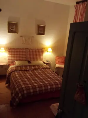 a bedroom with a bed with a checkered blanket at Hôtel Restaurant L'Aiglon in Zonza