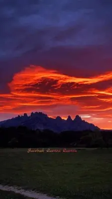 a sunset over a field with mountains in the background at Hôtel Restaurant L'Aiglon in Zonza