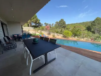 a patio with a table and a swimming pool at Villa Monte e Mare, piscine chauffée, climatisée à 5 mn de la plage de santa giulia in Porto-Vecchio