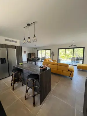a living room with a yellow couch and a table at Villa Monte e Mare, piscine chauffée, climatisée à 5 mn de la plage de santa giulia in Porto-Vecchio