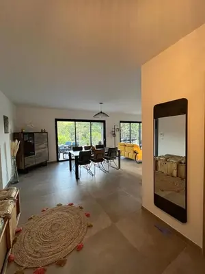 a living room with a dining table and a mirror at Villa Monte e Mare, piscine chauffée, climatisée à 5 mn de la plage de santa giulia in Porto-Vecchio