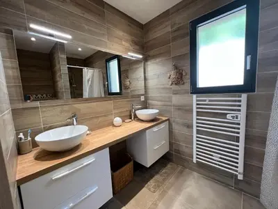 a bathroom with two sinks and a large mirror at Villa Monte e Mare, piscine chauffée, climatisée à 5 mn de la plage de santa giulia in Porto-Vecchio