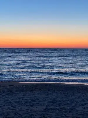 a sunset over the ocean with a beach at Les Lodges de la Plage U Dragulinu in Sari Solenzara
