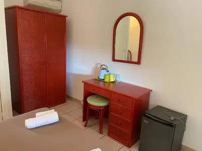 a bathroom with a red dresser with a chair and a mirror at Les Lodges de la Plage U Dragulinu in Sari Solenzara