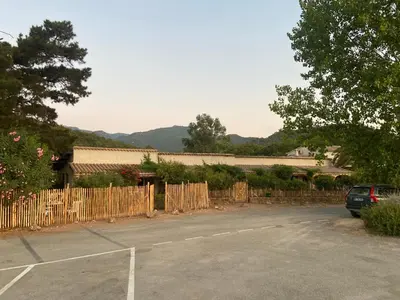 a car parked in a parking lot next to a fence at Les Lodges de la Plage U Dragulinu in Sari Solenzara