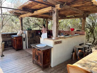 a woman standing in a kitchen on a deck at Domaine de la Coletta Maison traditionnelle in Coti-Chiavari
