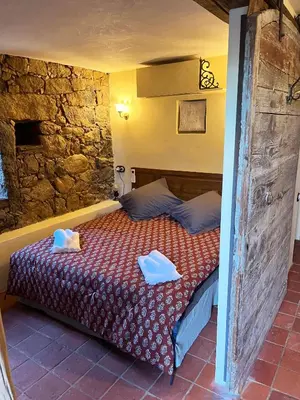 a bedroom with a bed with two towels on it at Domaine de la Coletta Maison traditionnelle in Coti-Chiavari