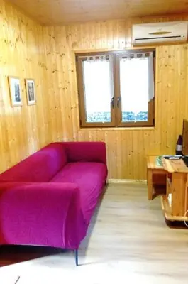 a living room with a purple couch and a table at Chalet de Santa in Corte