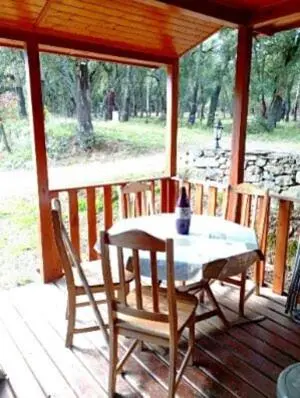 a table and chairs on a porch of a cabin at Chalet de Santa in Corte
