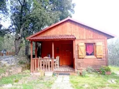 a small cabin with a porch in a field at Chalet de Santa in Corte