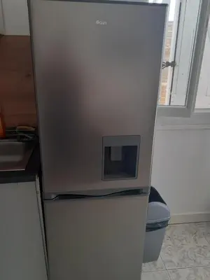 a refrigerator with a microwave on top of it at Maison à 200m de la mer, 10 mn de l'aéroport de Bastia et a 20mn du port in Lucciana