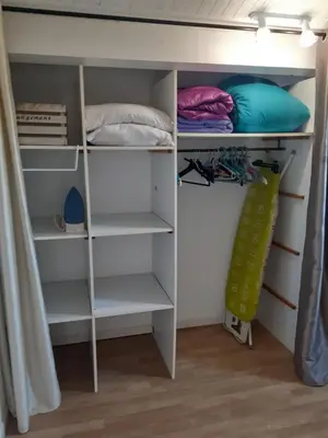 a closet with white shelves and pillows at Maison à 200m de la mer, 10 mn de l'aéroport de Bastia et a 20mn du port in Lucciana