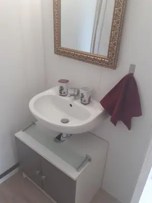 a bathroom with a sink and a mirror at Maison à 200m de la mer, 10 mn de l'aéroport de Bastia et a 20mn du port in Lucciana
