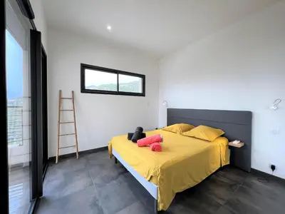 a bedroom with a bed with yellow sheets and pink pillows at Villa Cupabia vue mer in Viggianello