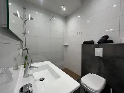 a white bathroom with a toilet and a sink at Villa Cupabia vue mer in Viggianello