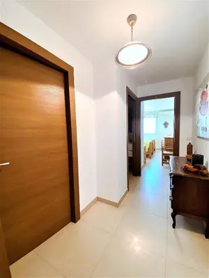 a hallway with a wooden door in a house at PORTO PIANO 2 pièces en centre-ville in Propriano