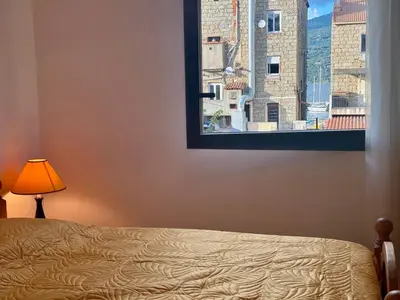 a bedroom with a bed and a window with a view at PORTO PIANO 2 pièces en centre-ville in Propriano