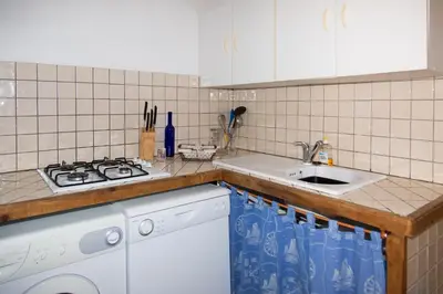a kitchen with a sink and a stove at Appartements A Merendella in Serriera
