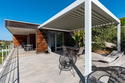a patio with awning and chairs and a table at Via Mare - Apt avec splendide vue in Grosseto-Prugna