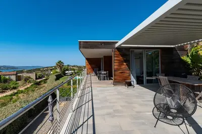 a balcony of a house with a table and chairs at Via Mare - Apt avec splendide vue in Grosseto-Prugna