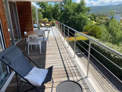 a balcony with chairs and tables on a house at Via Mare - Apt avec splendide vue in Grosseto-Prugna