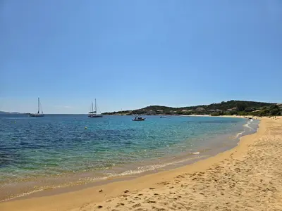 a sandy beach with boats in the water at Mare E Monti in Porto Pollo