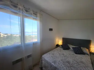 a bedroom with a bed and a large window at PORTICCIO villa dans résidence avec piscines 4-6 personnes BRILOC Appartements in Porticcio