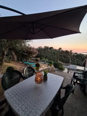a white table with chairs and an umbrella at PORTICCIO villa dans résidence avec piscines 4-6 personnes BRILOC Appartements in Porticcio
