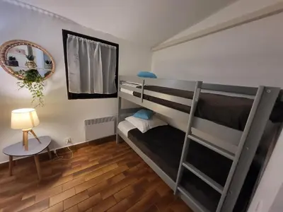 a bedroom with two bunk beds and a mirror at PORTICCIO villa dans résidence avec piscines 4-6 personnes BRILOC Appartements in Porticcio