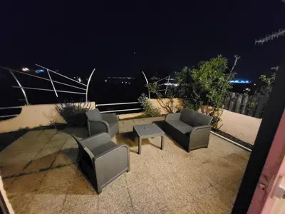 two chairs and a table on a balcony at night at PORTICCIO villa dans résidence avec piscines 4-6 personnes BRILOC Appartements in Porticcio
