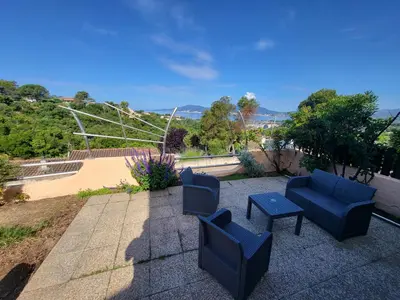 a patio with two blue chairs and a table at PORTICCIO villa dans résidence avec piscines 4-6 personnes BRILOC Appartements in Porticcio