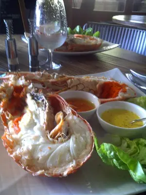 a plate of food with a shrimp and salad on a table at Hôtel Domaine A Flatta in Calenzana
