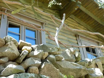 a pile of rocks in front of a log cabin at Hôtel Domaine A Flatta in Calenzana