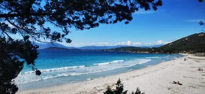 a view of a beach with people and the ocean at Studio avec terasse vue mer in Porticcio