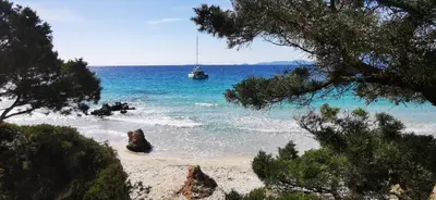 a boat is in the water on a beach at Studio avec terasse vue mer in Porticcio