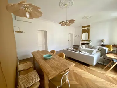 a living room with a table and a couch at Appartement de maître T3 80m2 en plein centre. in Ajaccio