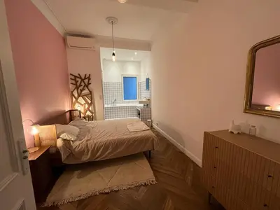 a small bedroom with a bed and a mirror at Appartement de maître T3 80m2 en plein centre. in Ajaccio