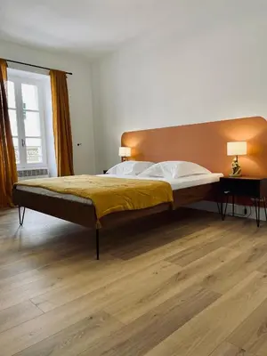 a large bed in a bedroom with a wooden floor at Superbe appartement T2 en plein centre d'Ajaccio, rue Fesch in Ajaccio