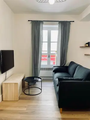 a living room with a black couch and a window at Superbe appartement T2 en plein centre d'Ajaccio, rue Fesch in Ajaccio