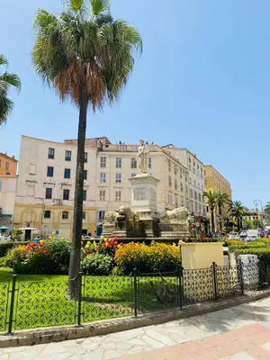 a palm tree in front of a building with a statue at Superbe appartement T2 en plein centre d'Ajaccio, rue Fesch in Ajaccio