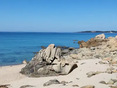a group of rocks on a beach with the ocean at chalets bois 150m de la plage in Olmeto
