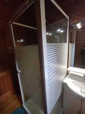 a glass shower in a bathroom with a toilet at chalets bois 150m de la plage in Olmeto