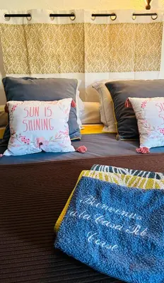 a bed with a pillow with a sign on it at Chambre d'hôtes Casa Tib in Prunelli-di-Fiumorbo