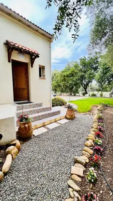 a house with a stone walkway next to a building at Chambre d'hôtes Casa Tib in Prunelli-di-Fiumorbo