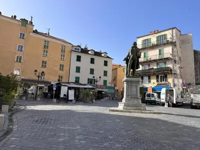 a statue in the middle of a street with buildings at Joli appartement F2 centre ville de Corte in Corte