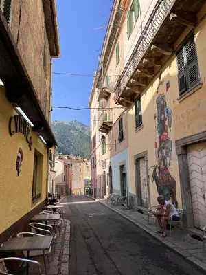 an empty street with tables and chairs in an alley at Joli appartement F2 centre ville de Corte in Corte