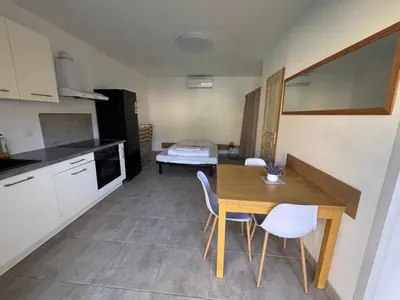 a kitchen and dining room with a table and chairs at Studio tout équipé à la nuitée ou plus,proche aéroport Bastia in Lucciana