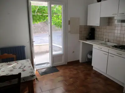 a kitchen with a door leading to a patio at T2 Casamozza Sud de Bastia climatisé in Monte