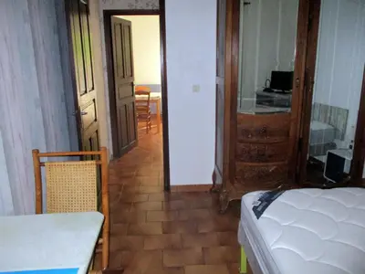 a room with a bed and a table and a door at T2 Casamozza Sud de Bastia climatisé in Monte